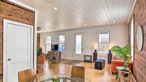A spacious living area with a glass table, wooden chairs, a sofa, and a large potted plant. - Contemporary San Antonio Home w/ Private Yard (San Antonio)