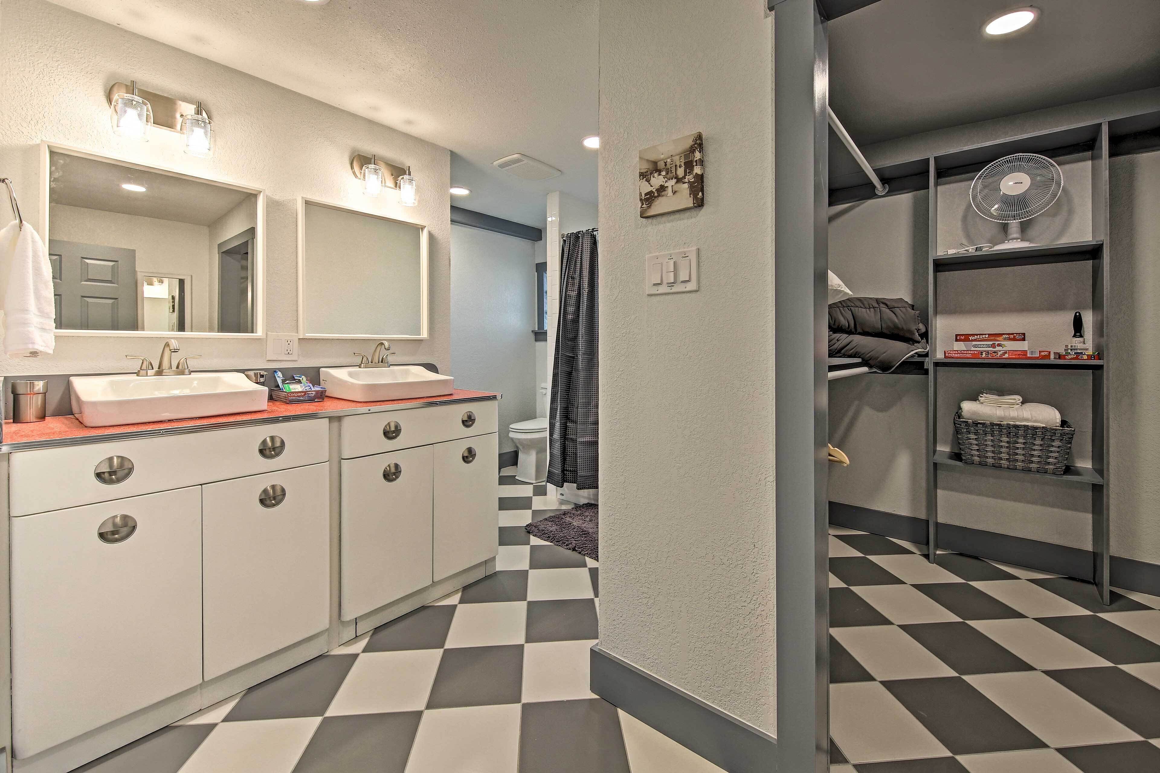 Une salle de bain moderne avec deux lavabos, un grand miroir et un carrelage à motifs géométriques.