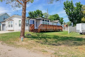 A mobile home with a porch and a fenced yard. - Spacious Family Home w/ Kayak + Deck on Bear Lake! (Garden City)
