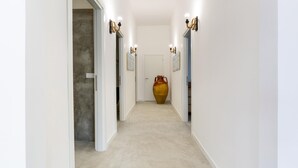 A hallway with white walls, a beige carpet, and a large vase at the end. - 3320 Villa Fiorezza - 3 PT by Barbarhouse (Maruggio)