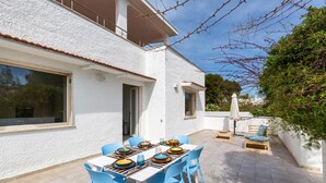 A patio with a table set for dining, blue chairs, and a wooden bench. - 3320 Villa Fiorezza - 3 PT by Barbarhouse (Maruggio)