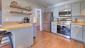 A modern kitchen with stainless steel appliances, wooden countertops, and light-colored cabinetry. - Modern Fayetteville Home < 1 Mi to U of A! (Fayetteville)