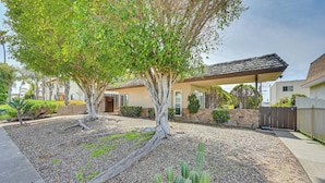 A residential area with a tree-lined driveway, a cactus in the foreground, and a house with a covered patio. - Cozy San Diego Escape w/ Yard, Near Beaches! (San Diego)