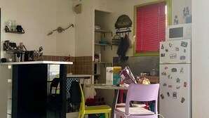 A kitchen with a counter, chairs, a refrigerator, and a window with blinds. - A bright and sunny one-bedroom apartment with a private terrace and a beautiful, unobstructed view. (Aix-en-Provence)