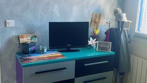 A room with a desk, a computer, a small speaker, and a decorative item on the wall. - A bright and sunny one-bedroom apartment with a private terrace and a beautiful, unobstructed view. (Aix-en-Provence)
