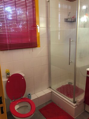 A bathroom with a toilet, shower, and a red mat. - A bright and sunny one-bedroom apartment with a private terrace and a beautiful, unobstructed view. (Aix-en-Provence)