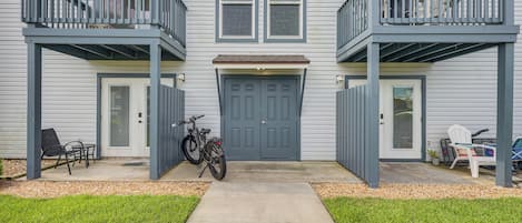 Una casa de dos pisos con un porche delantero, una bicicleta y mobiliario exterior.