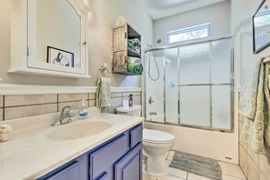 A bathroom with a sink, toilet, and glass-enclosed shower. - Bayou La Batre Stilted House on Snake Bayou! (Bayou La Batre)