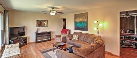 A living room with a sofa, coffee table, TV, and a painting on the wall.