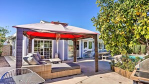 A covered patio area with outdoor furniture, a pool, and a barbecue grill. - Deluxe Laguna Hills Home w/ Outdoor Oasis! (Laguna Hills)