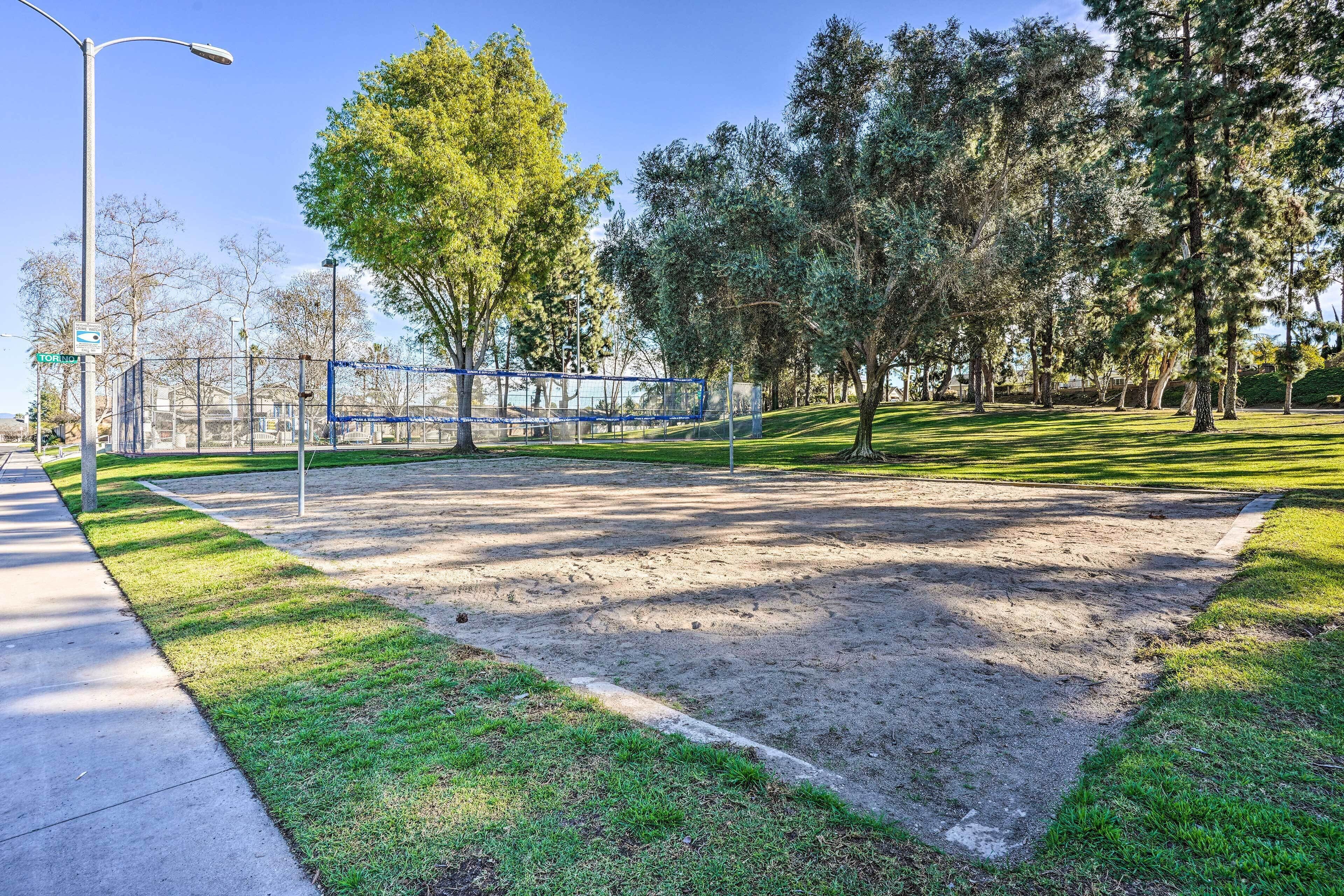A park with a sandbox, trees, and a playground.