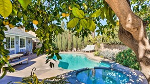 A swimming pool with a hot tub, surrounded by a patio with benches and a house in the background. - Deluxe Laguna Hills Home w/ Outdoor Oasis! (Laguna Hills)