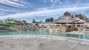 A pool area with a sign for 'TIKI HUT', a thatched-roof structure, and a waterfall feature.