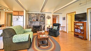 A living room with a fireplace, a television, and a bookshelf. - 'willow Point' ~ Lake Champlain House w/ 2 Kayaks! (Isle La Motte)