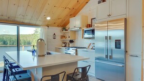 Una cocina moderna con una isla grande, electrodomésticos de acero inoxidable y vistas al exterior.