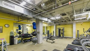 Een sportschool met loopbanden, gewichten en fitnessballen.