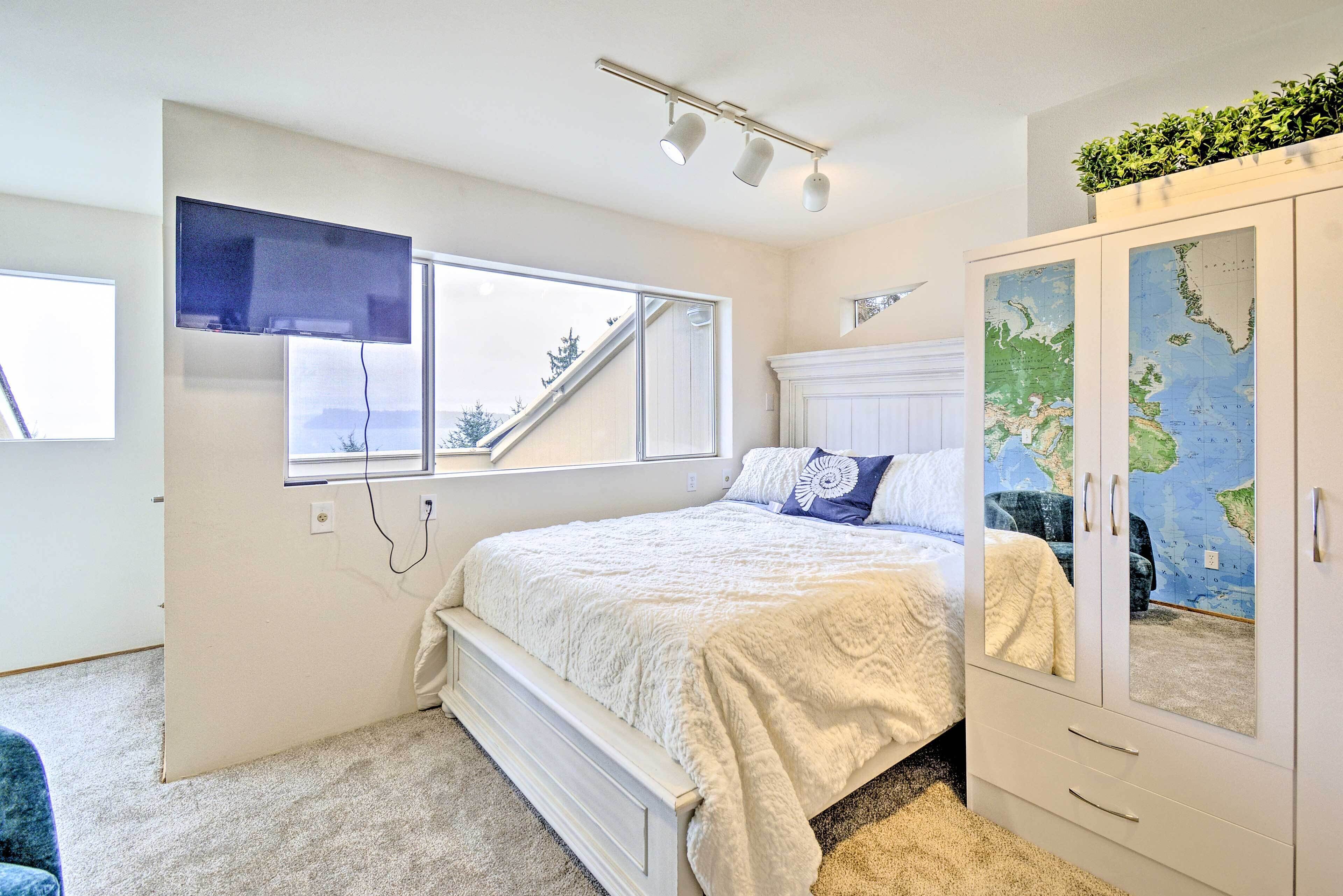 A bedroom with a bed, a wardrobe, a map on the wall, and a window.