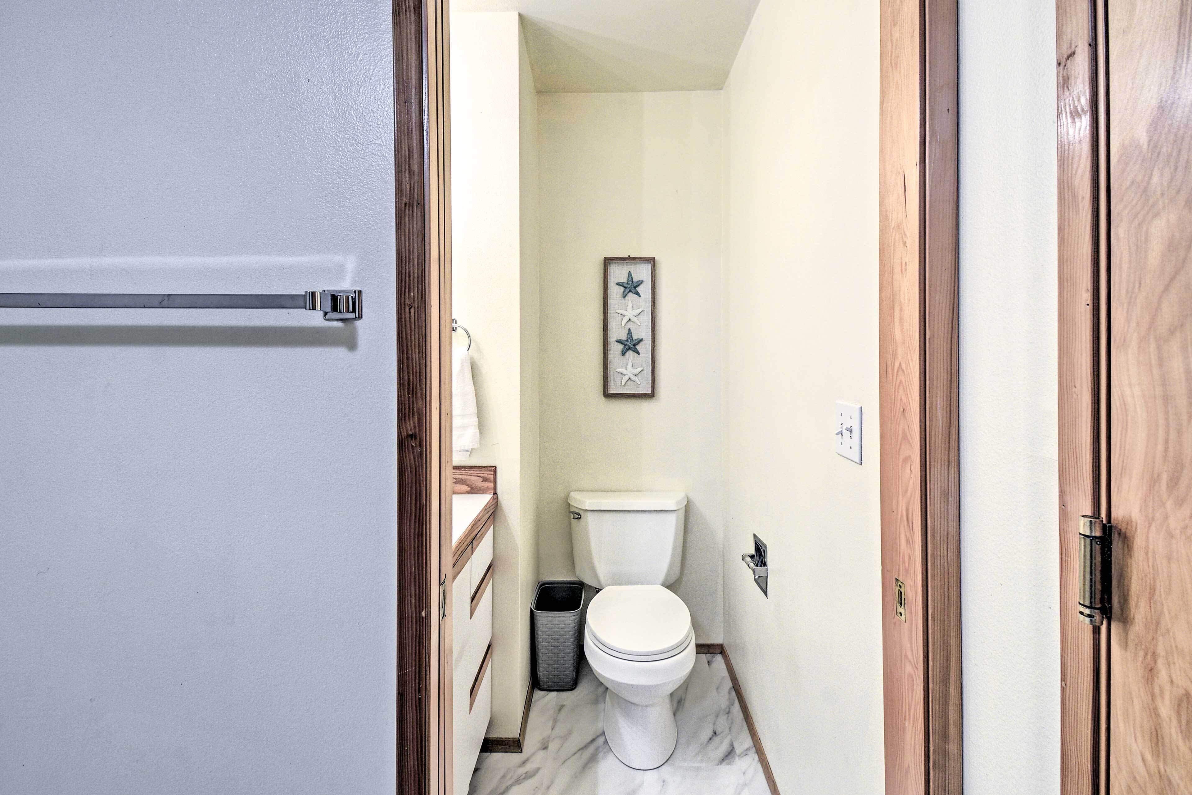 Une petite salle de bain avec des toilettes, une poubelle et une étoile décorative fixée au mur.