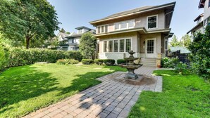 A two-story house with a well-maintained lawn and a stone pathway leading to the front door.