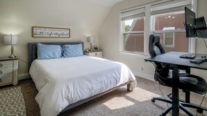 A bedroom with a bed, bedside tables, a desk, and a chair. - Near Churchill Downs: Pet Friendly, Fenced Yard! (Louisville)