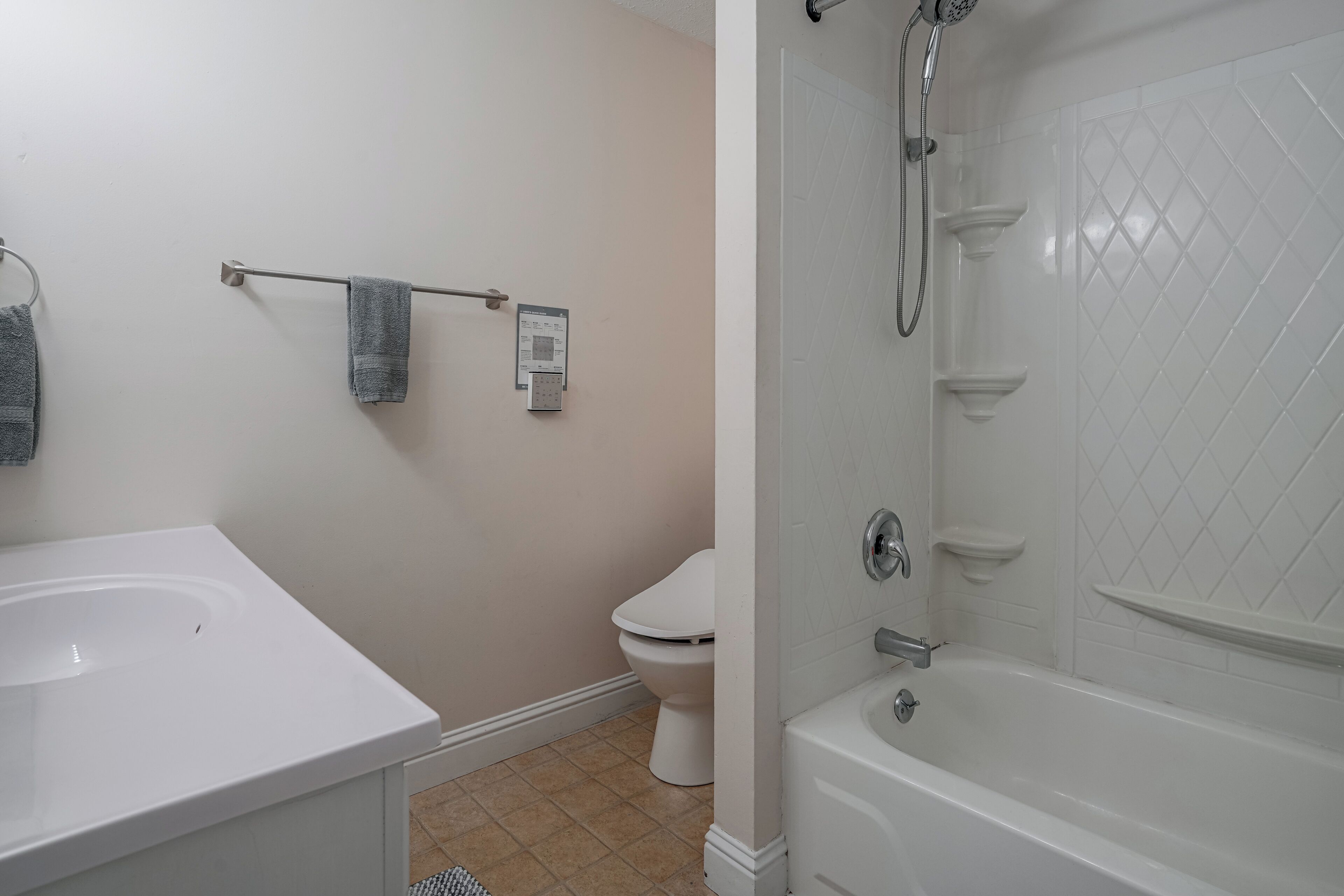 A bathroom with a white bathtub, a toilet, and a sink.