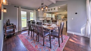 A dining area with a wooden table, dark chairs, and a patterned rug.