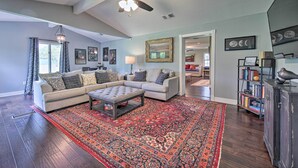 A living room with a ceiling fan, two sofas, a coffee table, and a patterned rug.