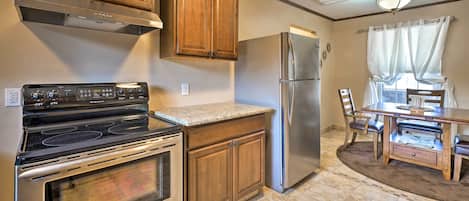 Una cocina con armarios de madera, estufa de acero inoxidable y refrigerador.
