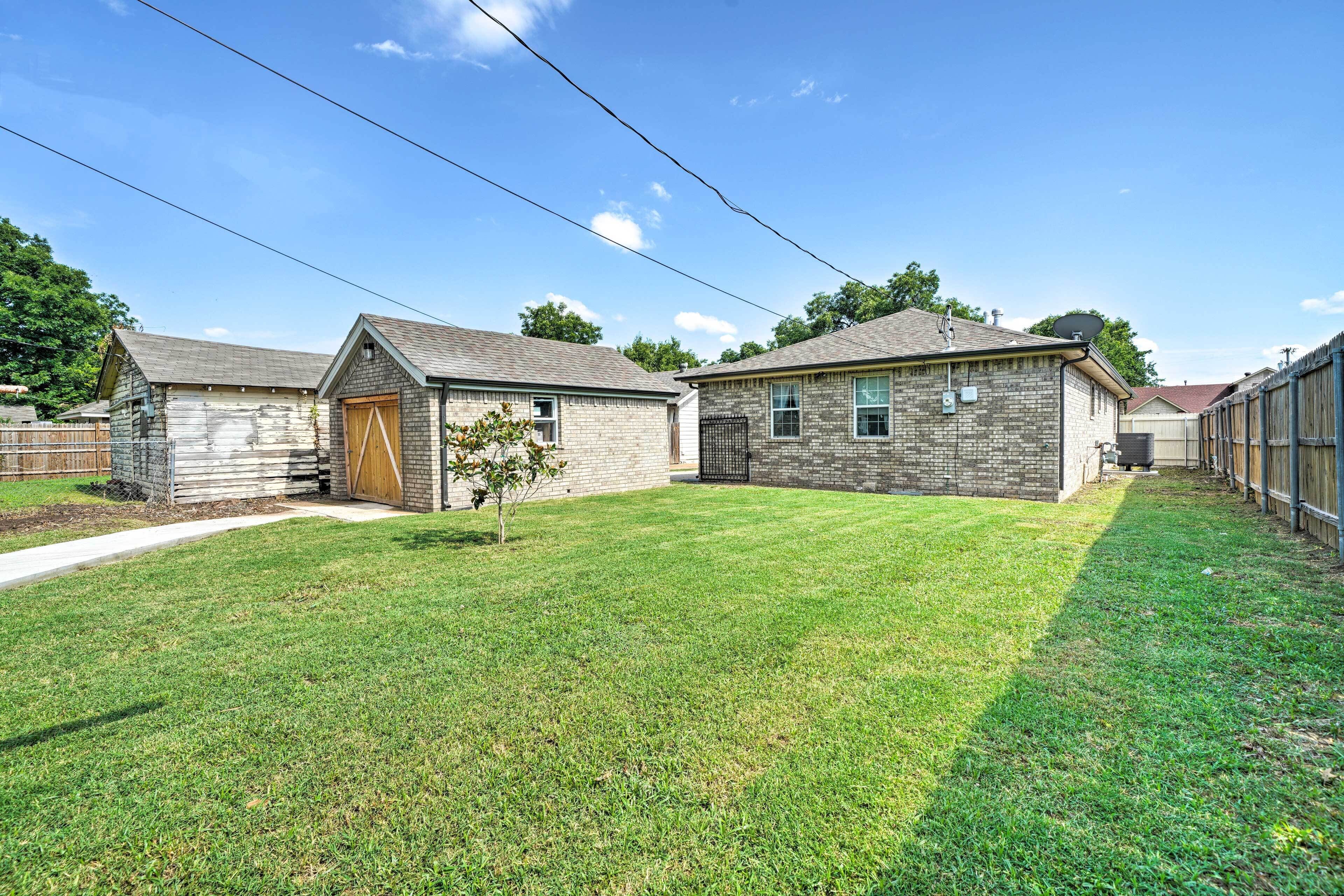 A residential property with a well-maintained lawn, a wooden garage door, and a brick house with a chimney.
