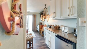 A kitchen with white cabinets, a wooden countertop, a built-in dishwasher, and a hanging light fixture. - Family Beach Retreat w/ Pool & Views in Galveston (Galveston)
