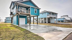 A modern two-story house with a balcony, a garage, and a covered porch.