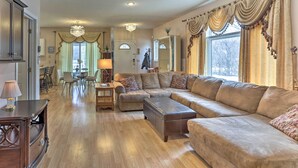A spacious living room with a large sectional sofa, a dining area with a table and chairs, and a kitchen in the background. - Eagan Home w/ Porch - 5 Mi to Mall of America! (Eagan)