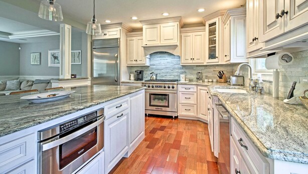 A kitchen with white cabinetry, granite countertops, stainless steel appliances, and a stone backsplash. - West Dover Home - 3 Miles to Mount Snow Resort! (West Dover)