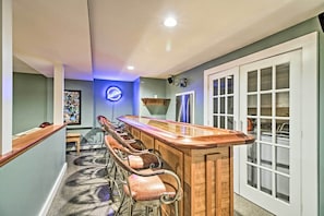 A kitchen with a bar area, a refrigerator, and a large window with blinds. - West Dover Home - 3 Miles to Mount Snow Resort! (West Dover)