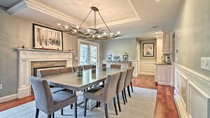 A dining area with a large table, chairs, a fireplace, and a chandelier. - West Dover Home - 3 Miles to Mount Snow Resort! (West Dover)