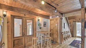 A wooden interior with a bar area, wooden doors, and a staircase.