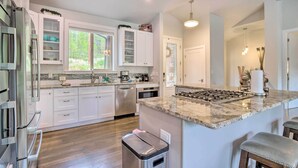 A modern kitchen with white cabinetry, a granite countertop, stainless steel appliances, and a window providing natural light. - 3 Mi to Ski Resort: Hot Tub Haven in Breckenridge! (Breckenridge)