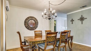 A dining room with a wooden table and chairs, a chandelier, and decorative wall art. - Charming Lake Retreat w/ Patio & Boat Parking! (Canyon Lake)