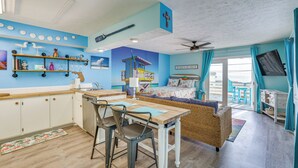 A compact living space with a kitchenette, dining area, and a bedroom with a view. - PCB Apt w/ Balcony & Gulf Views: Walk to Beach (Panama City Beach)