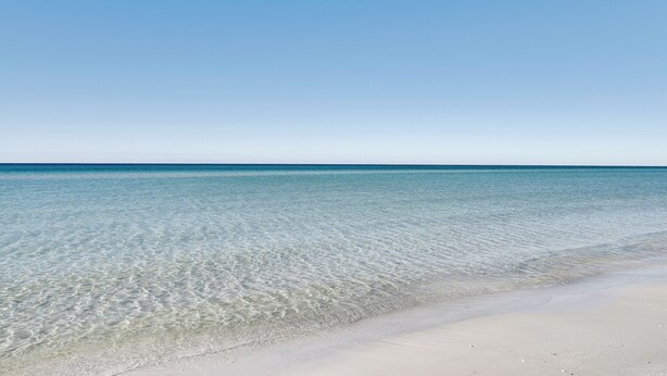 A clear view of a beach with calm waters and a sandy shore. - PCB Studio w/ Private Patio: Steps to Beach! (Panama City Beach)