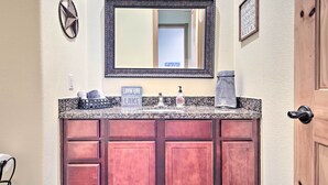 A bathroom with a large mirror, a sink with a faucet, and a cabinet below. - Lakeview Escape w/ Hot Tub, 1 Mi to Canyon Lake (Canyon Lake)