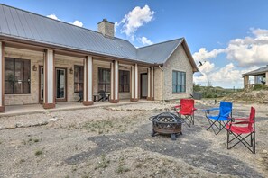 A building with a stone facade, large windows, and a covered patio area with outdoor seating. - Lakeview Escape w/ Hot Tub, 1 Mi to Canyon Lake (Canyon Lake)