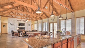 A spacious kitchen with a large island, wooden beams, and a stone accent wall. - Lakeview Escape w/ Hot Tub, 1 Mi to Canyon Lake (Canyon Lake)