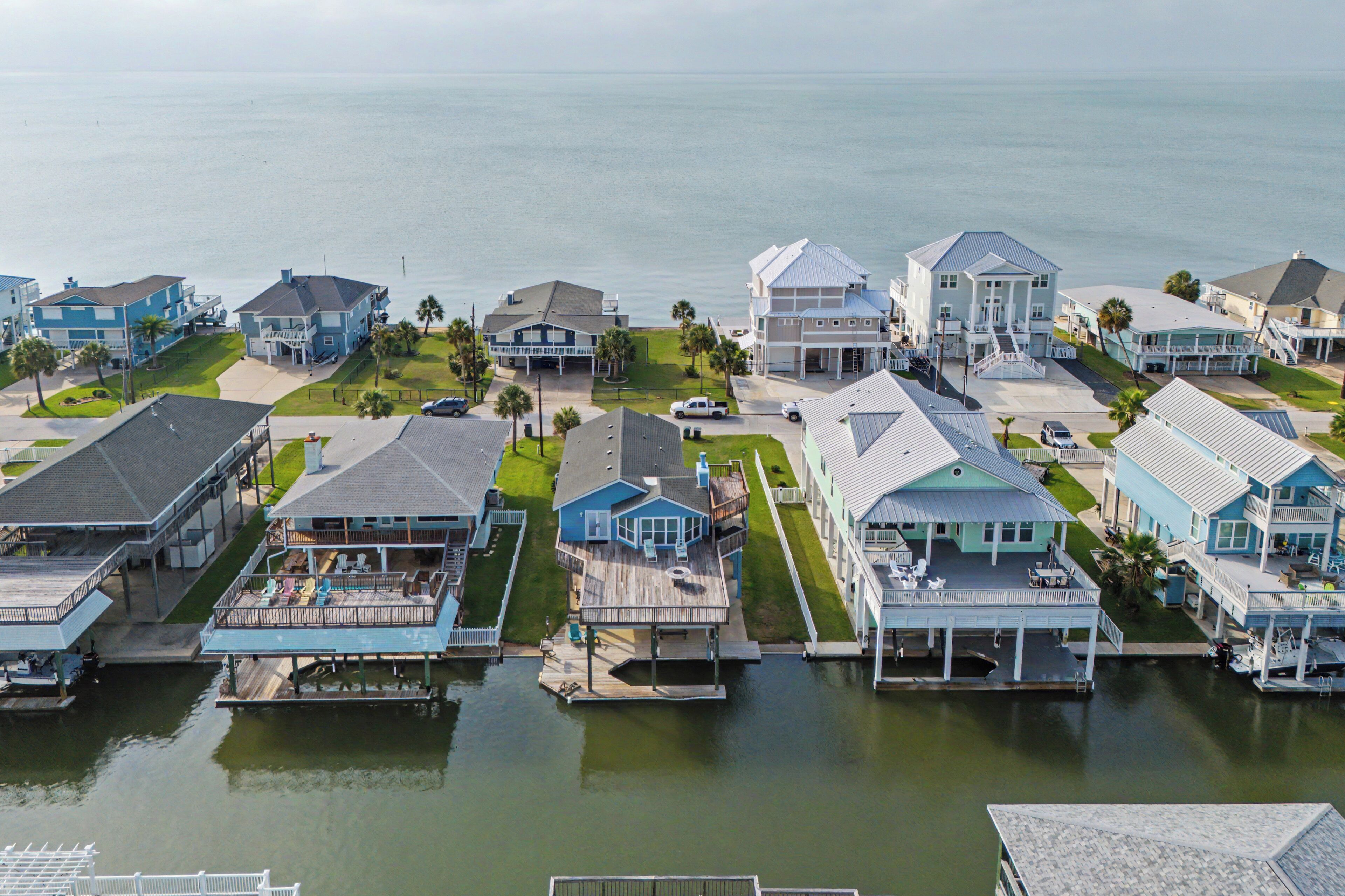 Un quartier résidentiel en bord de mer où les maisons sont reliées par des passerelles au-dessus de l’eau, et qui comprend des balcons et un port de plaisance.