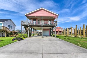 A two-story house with a balcony, a garage, and a well-maintained lawn. - Walk to Sea Isle Beach: Bright Galveston Home! (Galveston)