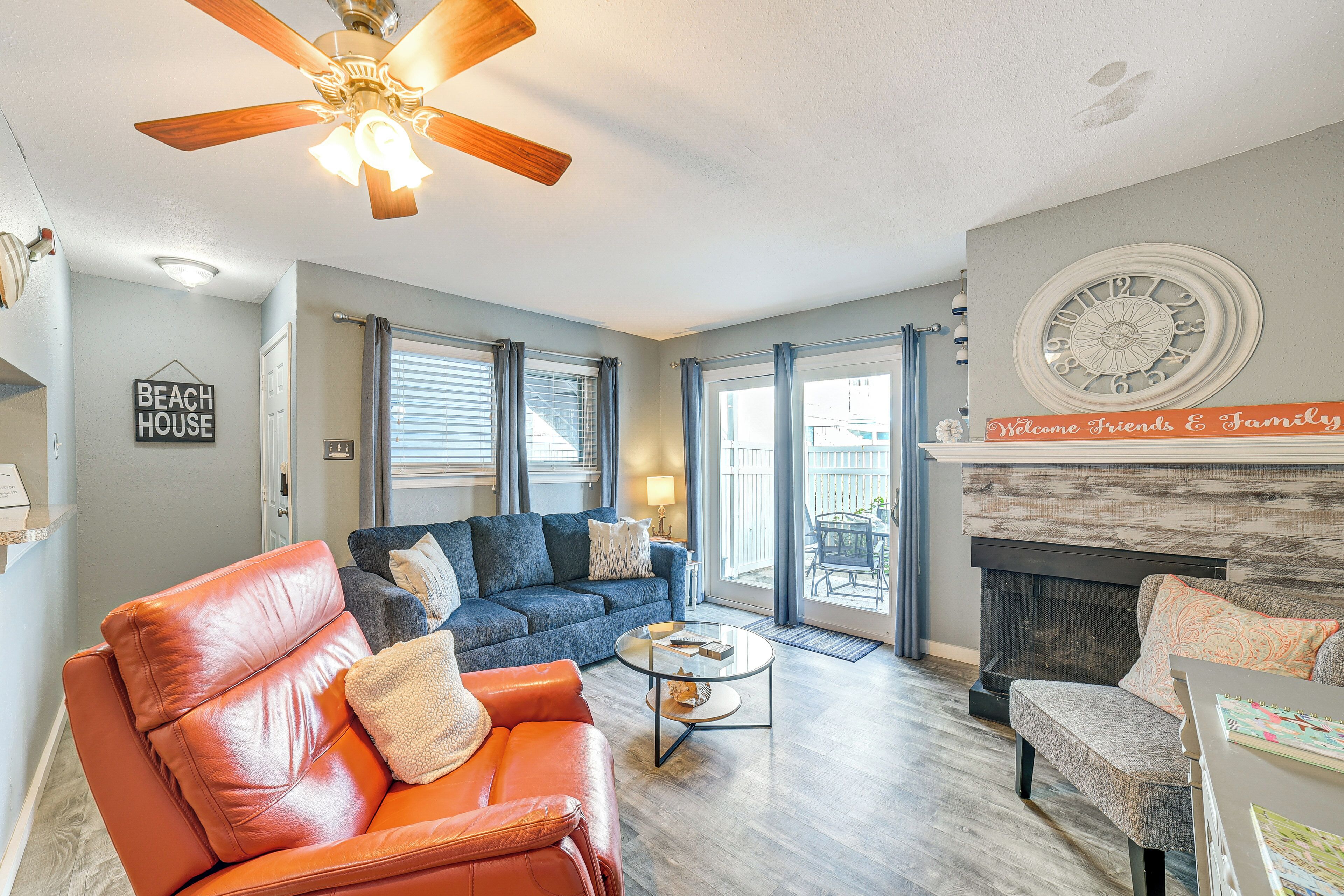 A living room with a leather sofa, a blue couch, a coffee table, and a fireplace.