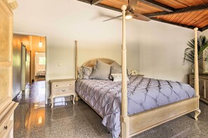 A four-poster bed with a tufted headboard, a wooden ceiling fan, and a marble floor. - Kailua-kona Home w/ Tropical Bar: Walk to Beach! (Kailua-Kona)