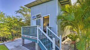 A two-story house with a balcony, a staircase, and a garden with palm trees. - 1 Mile to Magic Sands Beach: Kailua-kona Cottage (Kailua-Kona)