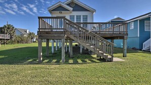 A two-story house with a wooden deck and stairs leading to a balcony. - Steps to Beach! 'surf Cottage' in Galveston (Galveston)