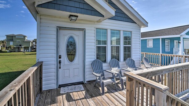 A small, single-story house with a porch, a door with a glass panel, and two Adirondack chairs. - Steps to Beach! 'surf Cottage' in Galveston (Galveston)